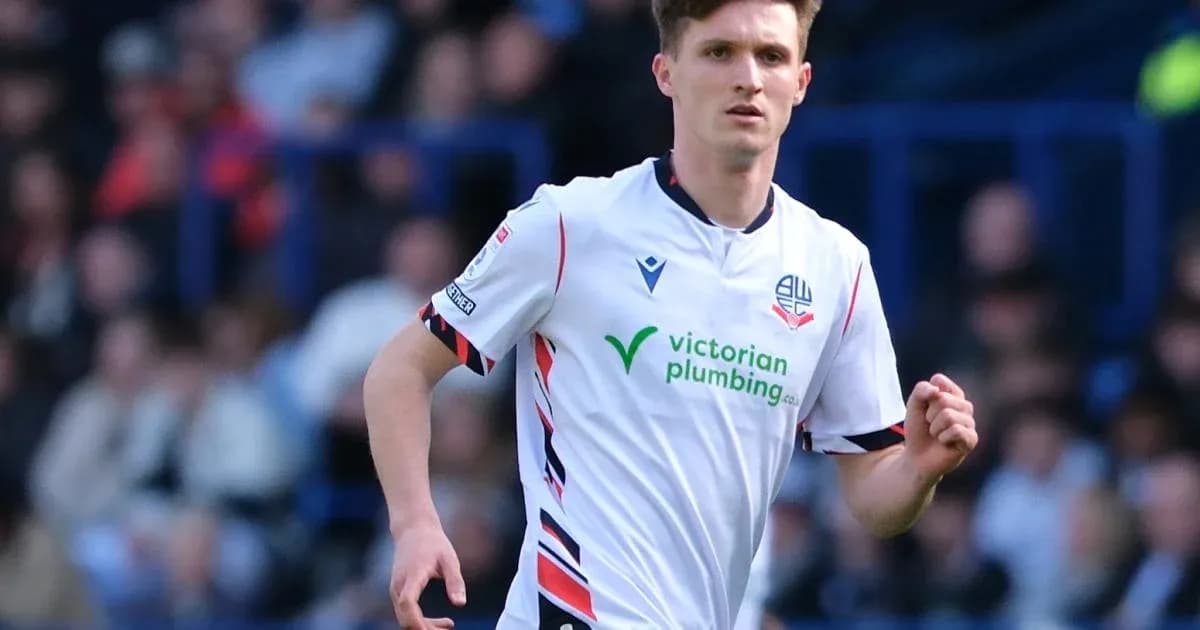 Player in white kit running on the pitch Player in white kit running on the pitch