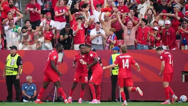 Players celebrating a goal with fans in the stands Players celebrating a goal with fans in the stands