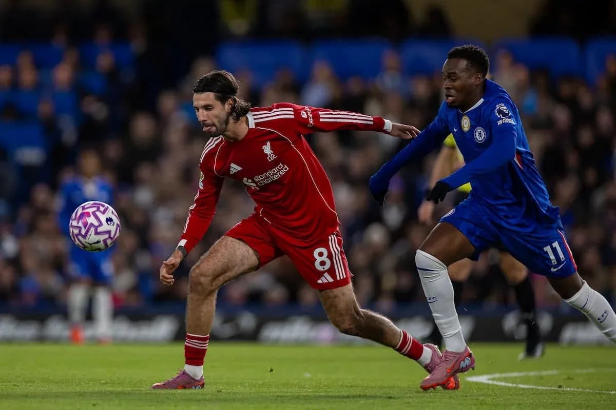 Liverpool player dribbling past Chelsea opponent Liverpool player dribbling past Chelsea opponent