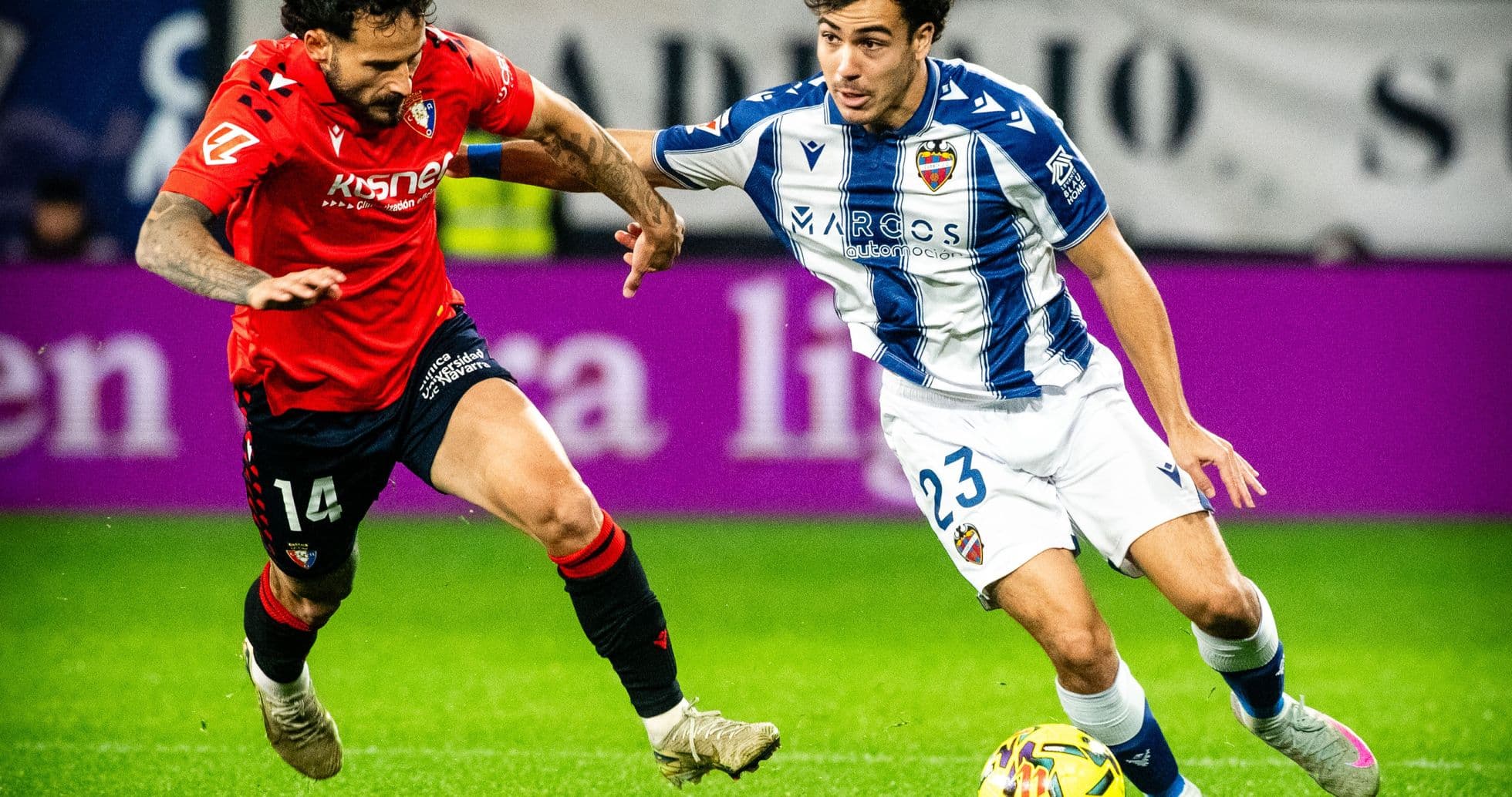 Levante player dribbling past Osasuna defender Levante player dribbling past Osasuna defender