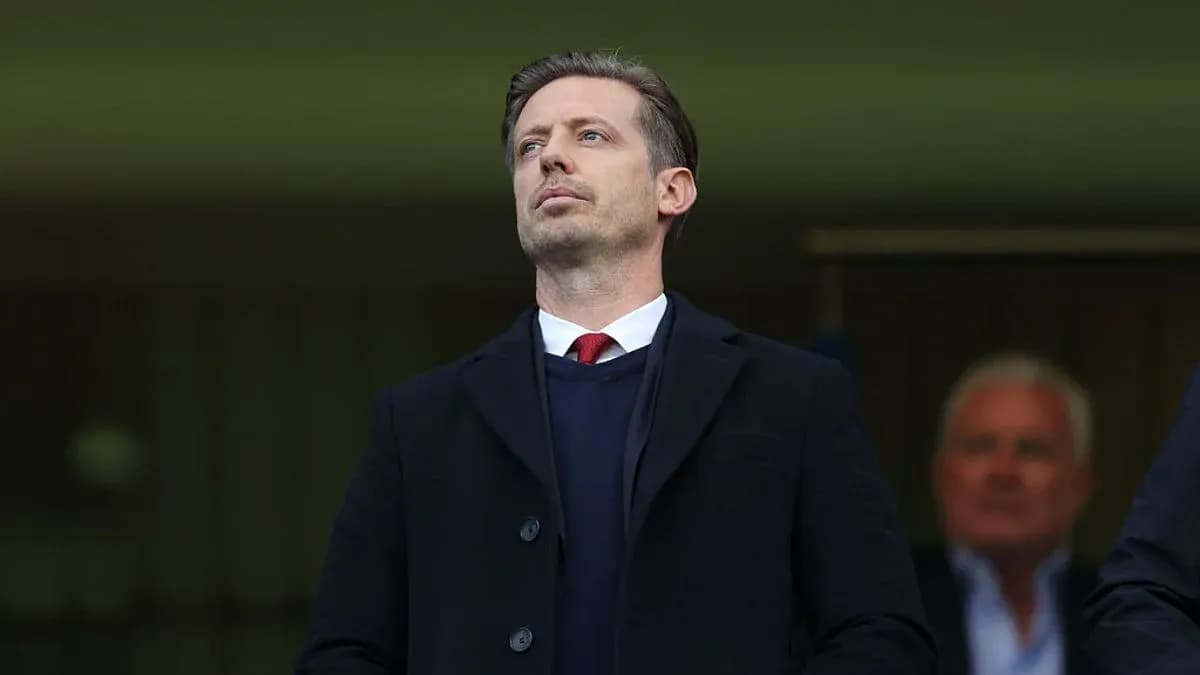 Man in a black coat observing from a stand Man in a black coat observing from a stand