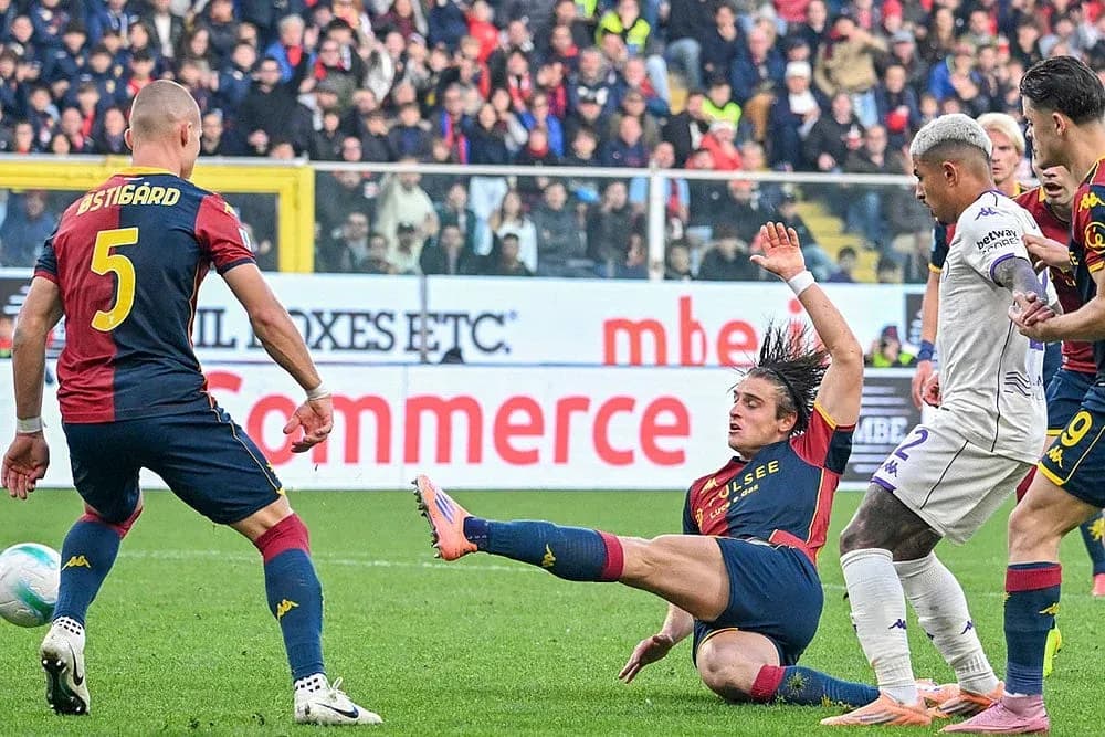 Genoa player challenging Fiorentina opponent during match Genoa player challenging Fiorentina opponent during match