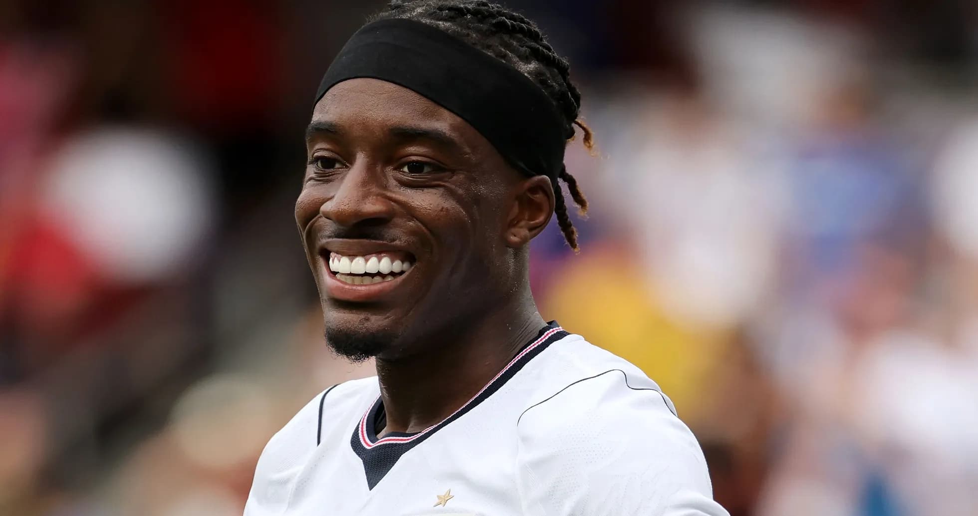 Player smiling while wearing team jersey on field Player smiling while wearing team jersey on field