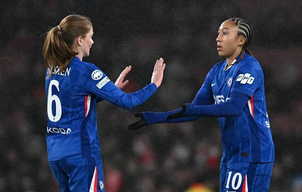 Two Chelsea players exchanging high-fives on field Two Chelsea players exchanging high-fives on field