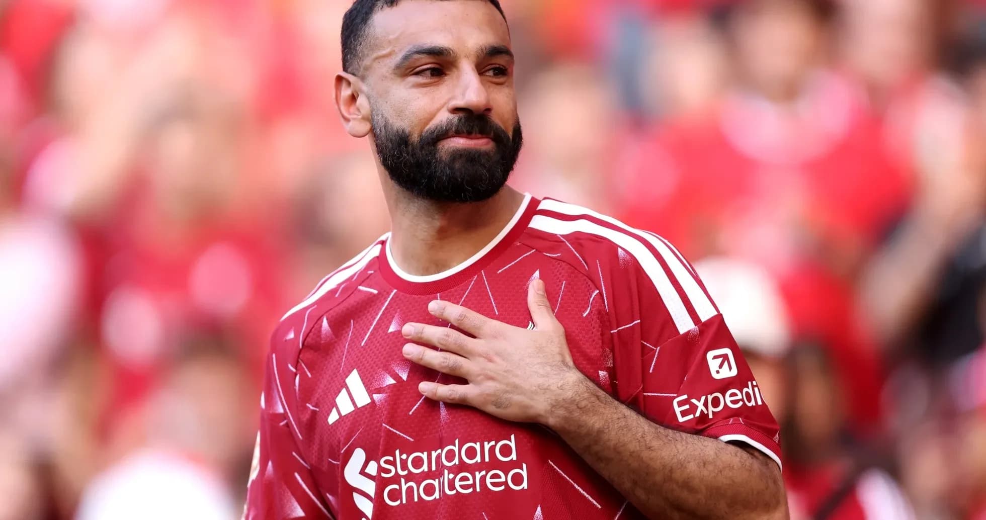 Player in red jersey gesturing to fans Player in red jersey gesturing to fans