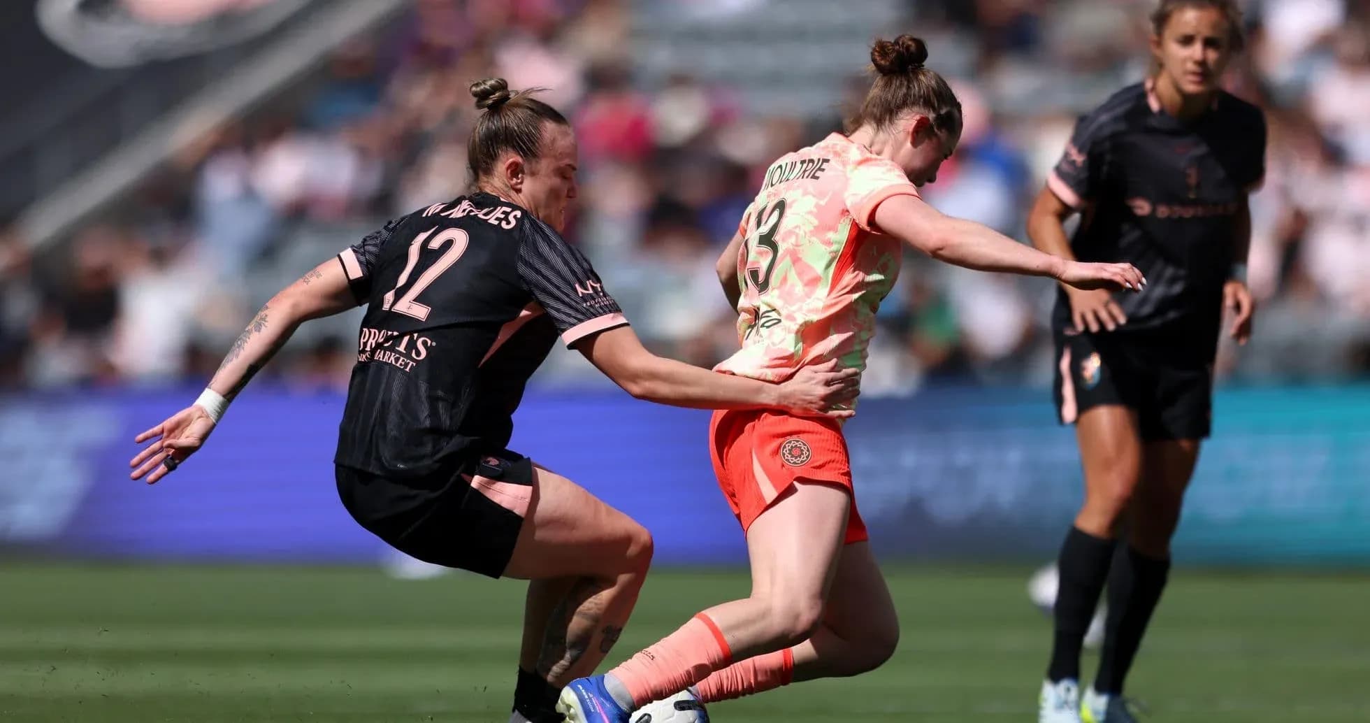 Player tackles opponent during NWSL match Player tackles opponent during NWSL match