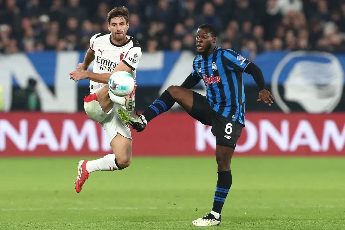 AC Milan player challenging Atalanta opponent AC Milan player challenging Atalanta opponent