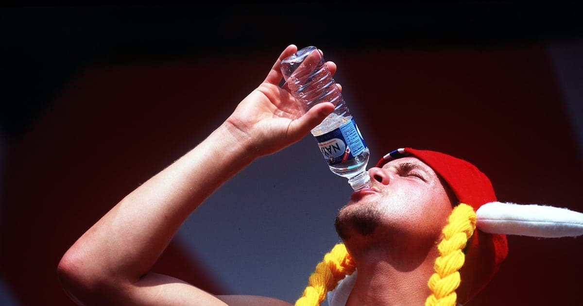 Person in a hat drinking water from bottle Person in a hat drinking water from bottle