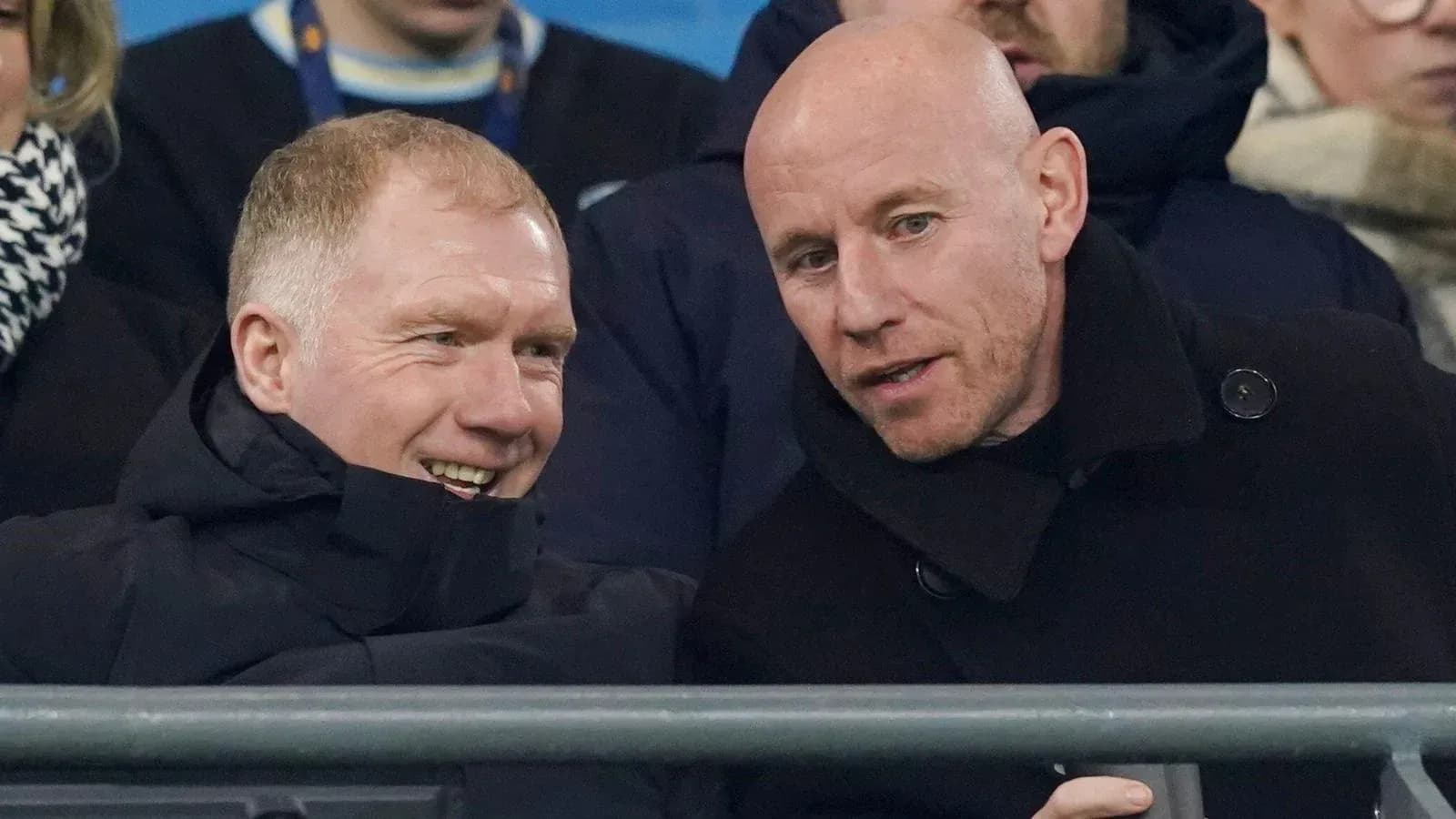 Two men talking in the stands at a game Two men talking in the stands at a game