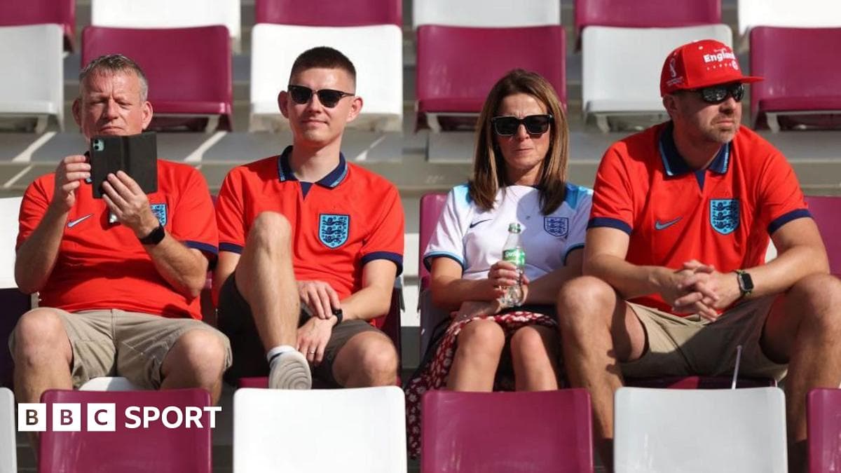 Fans wearing England jerseys sitting in stadium seats Fans wearing England jerseys sitting in stadium seats