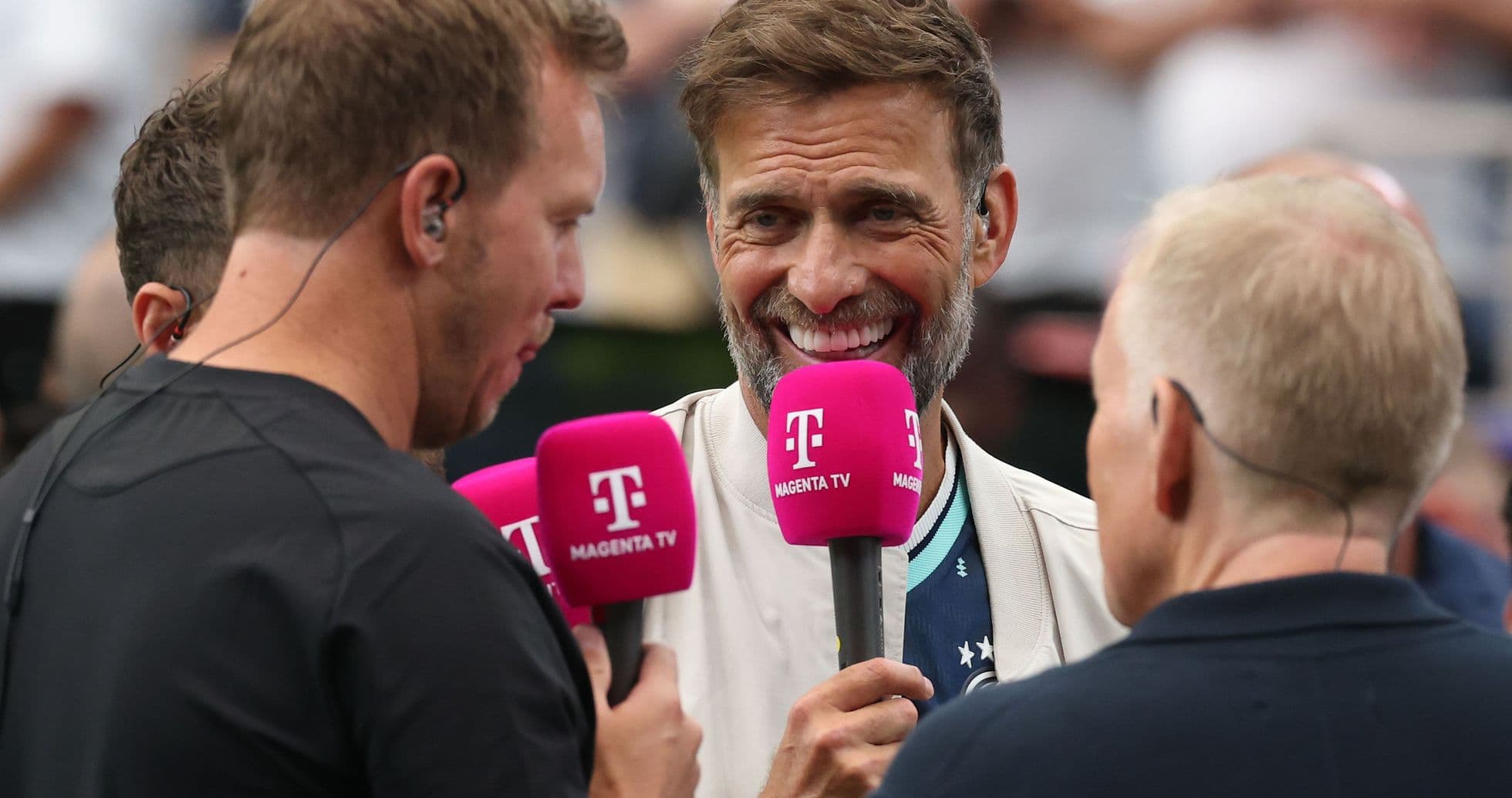 Four individuals holding microphones during an interview Four individuals holding microphones during an interview