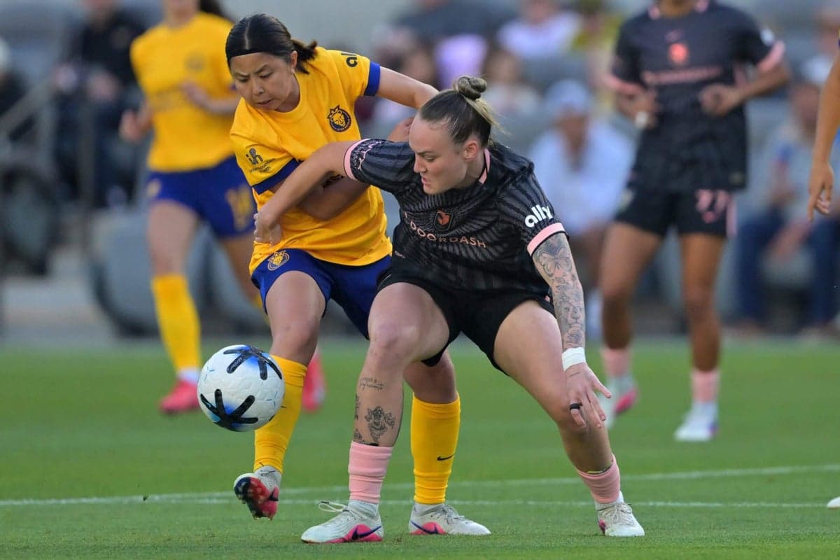 Players competing for the ball in NWSL match Players competing for the ball in NWSL match