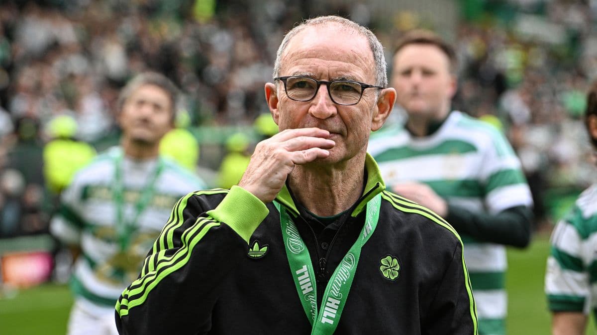 Manager walking on the pitch with team behind Manager walking on the pitch with team behind