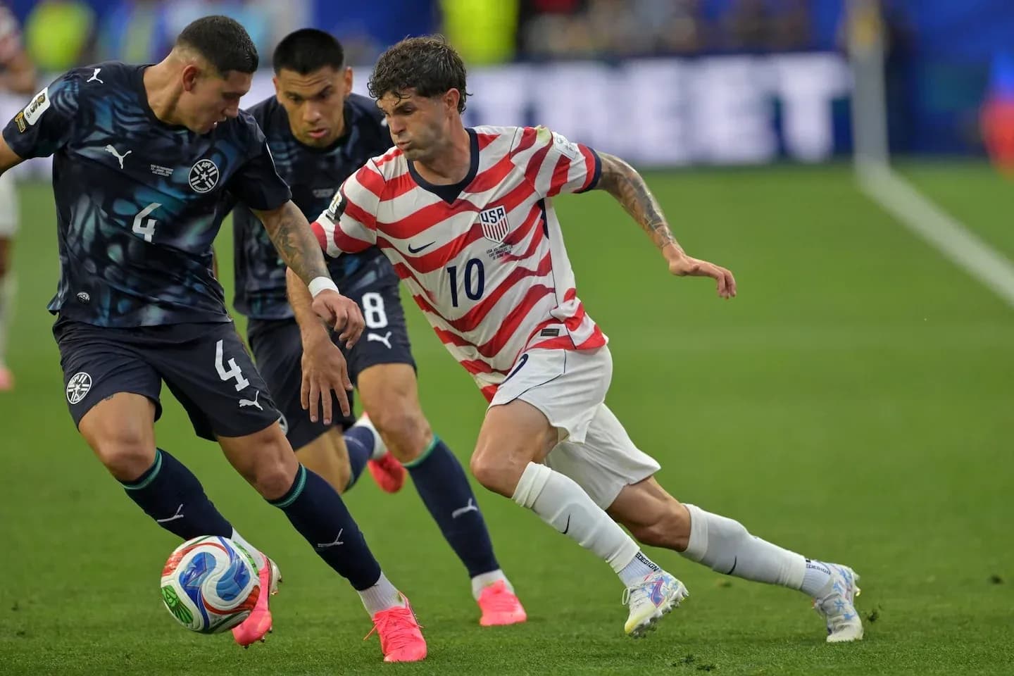 Christian Pulisic dribbling past two defenders during match Christian Pulisic dribbling past two defenders during match