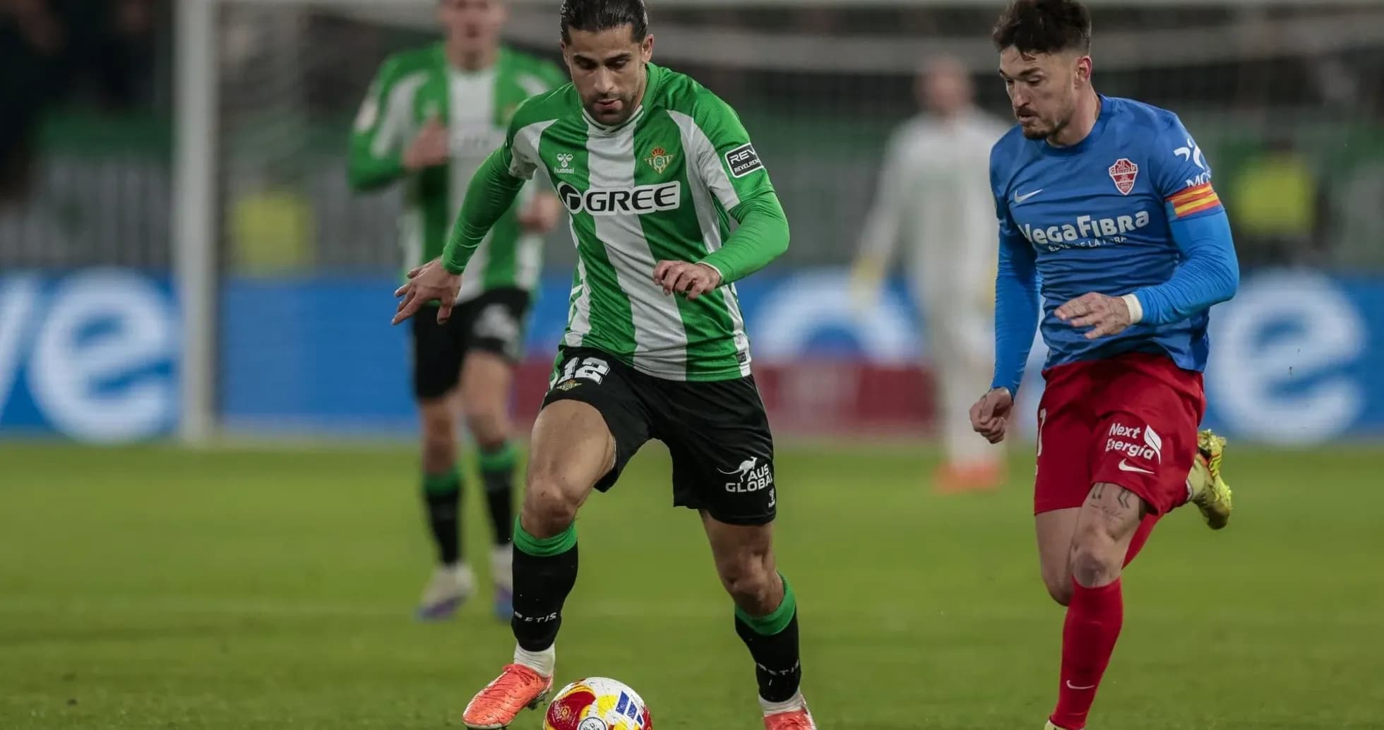 Real Betis player dribbling against Elche defender Real Betis player dribbling against Elche defender