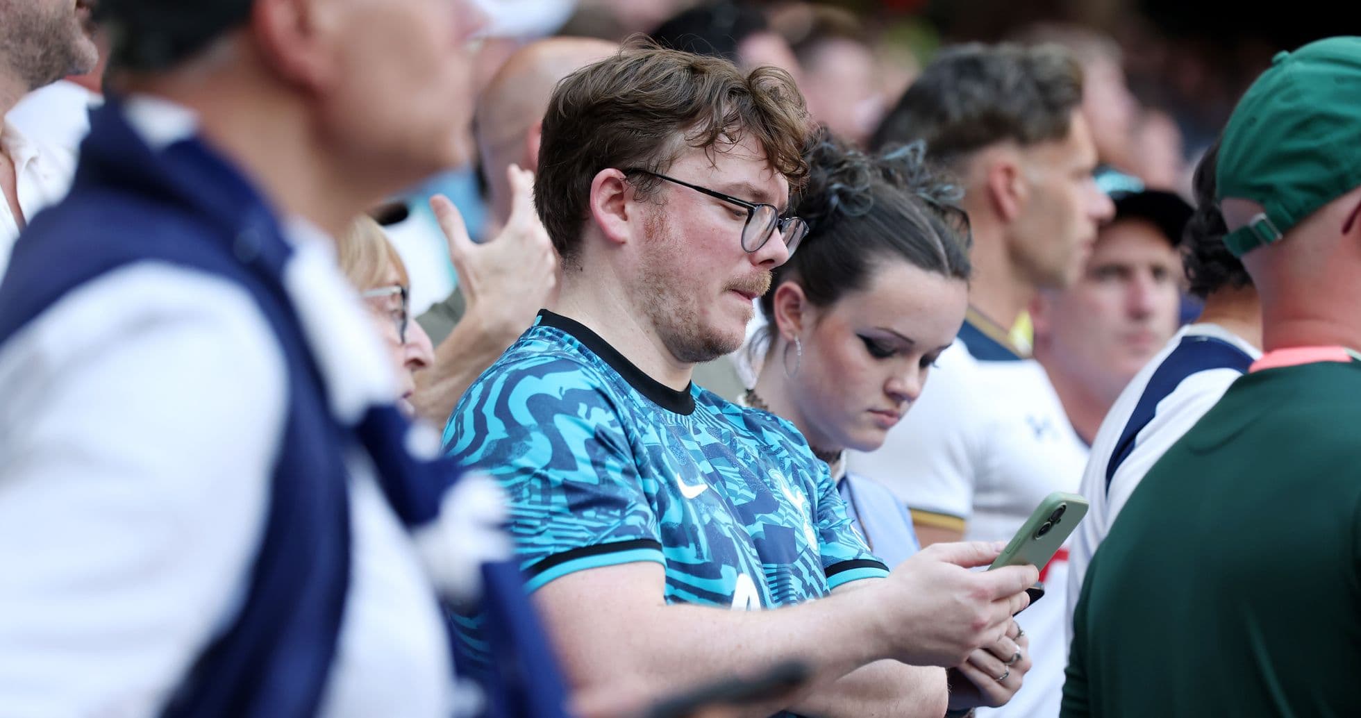 Fans focused on their phones during the match Fans focused on their phones during the match