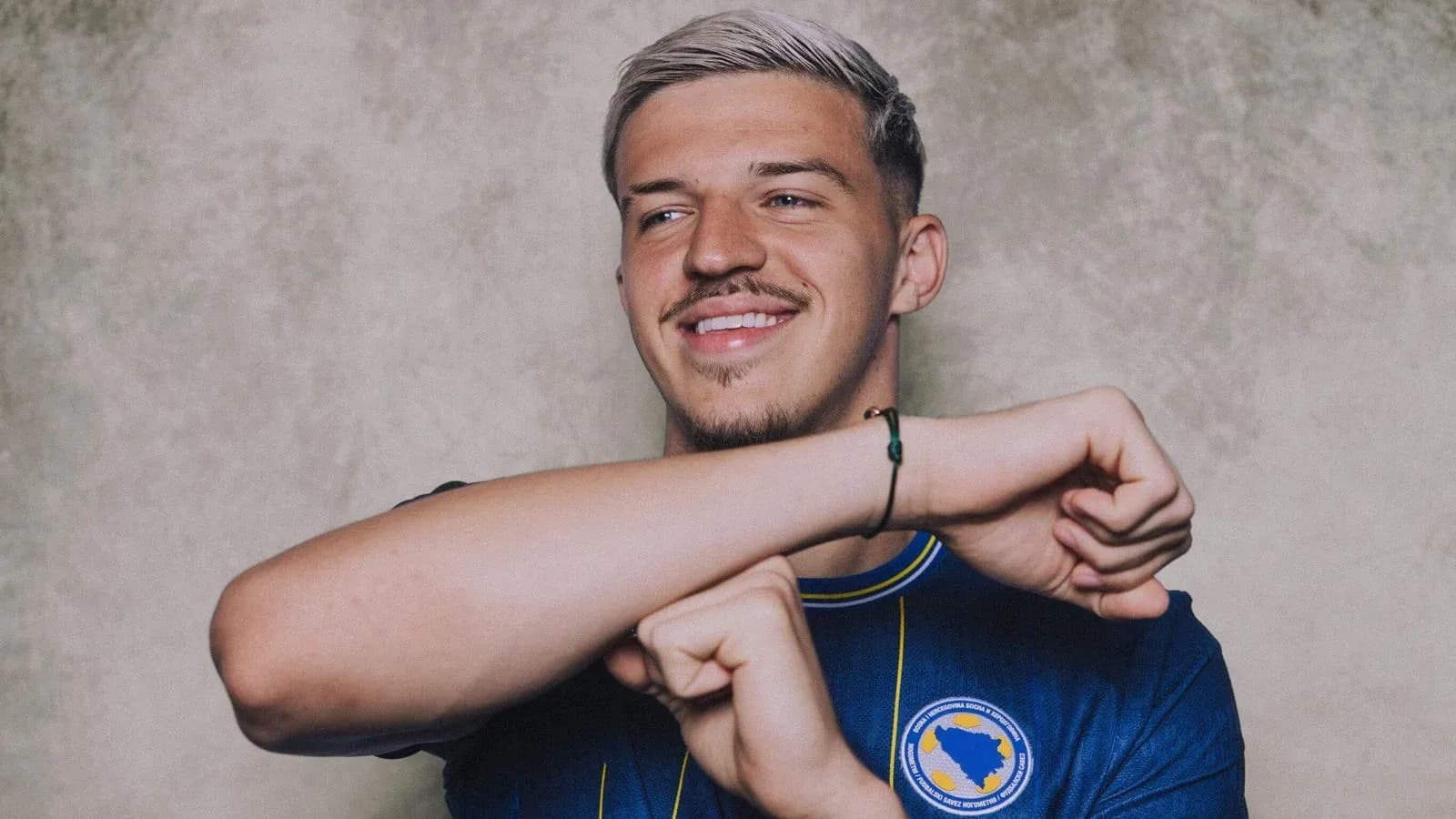 Player in blue jersey smiling and posing Player in blue jersey smiling and posing
