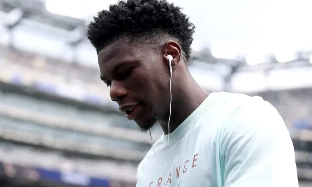 Player wearing earbuds, looking down on the field Player wearing earbuds, looking down on the field