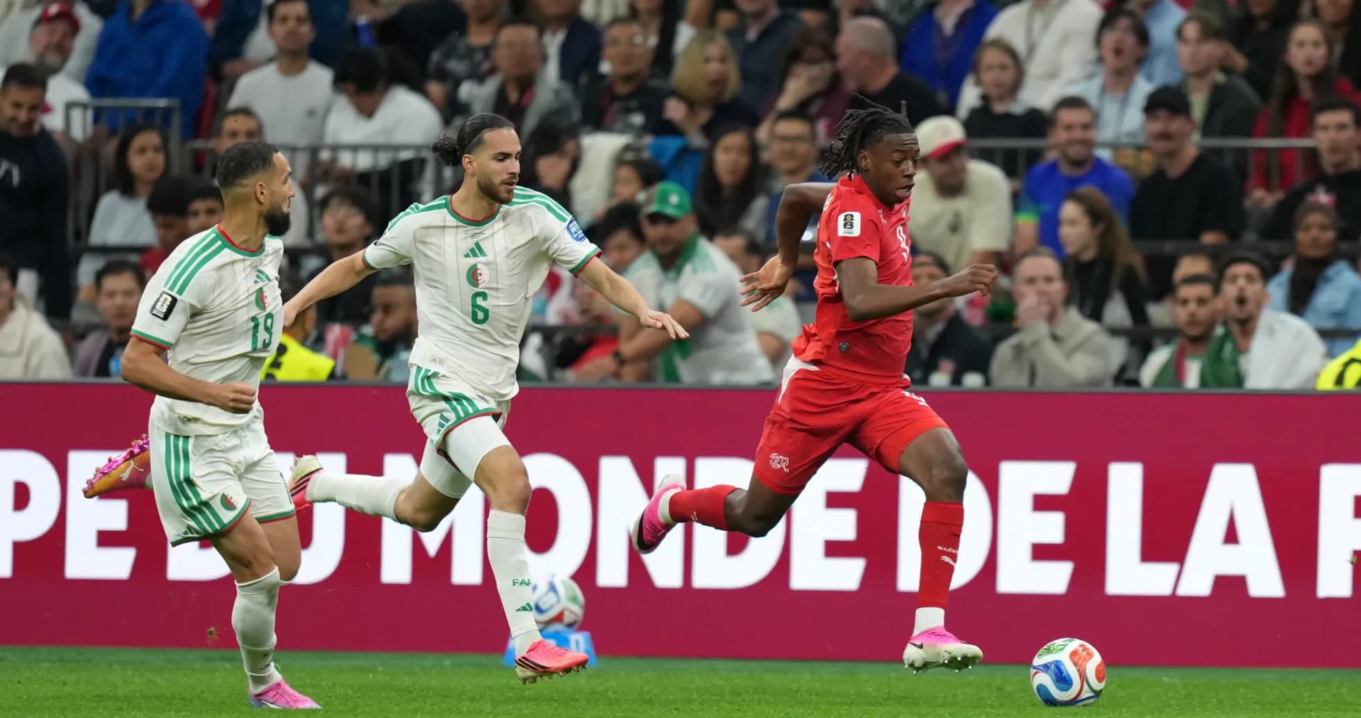 Switzerland player advancing against Algeria defenders Switzerland player advancing against Algeria defenders