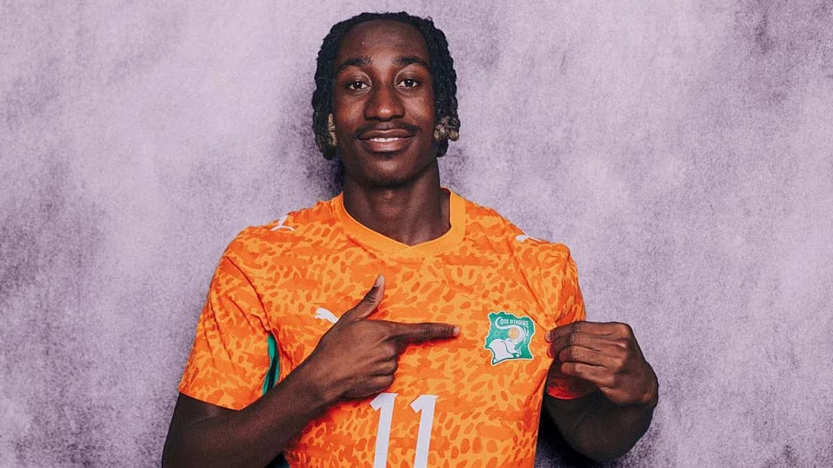Player in orange jersey pointing to national emblem Player in orange jersey pointing to national emblem