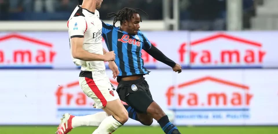 AC Milan player challenging Atalanta opponent AC Milan player challenging Atalanta opponent