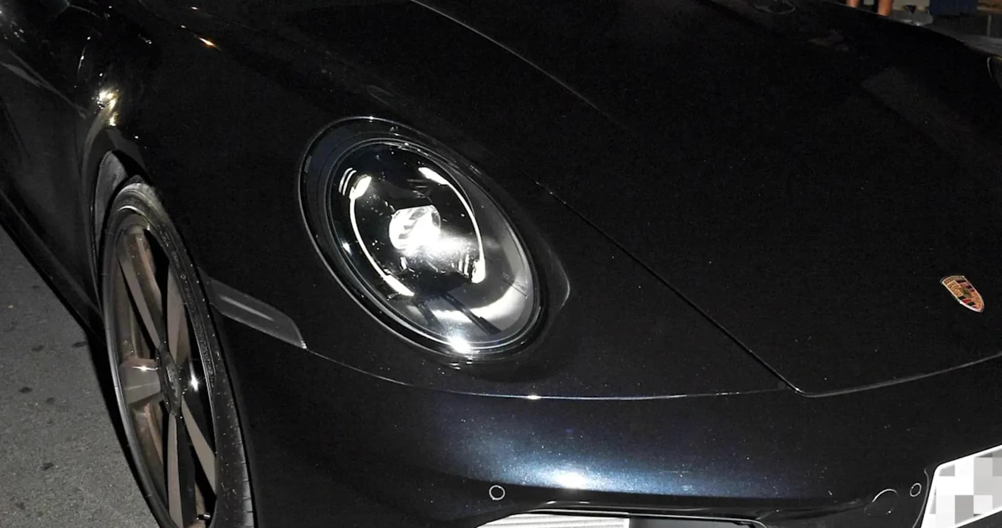 Two men sitting in a black Porsche sports car Two men sitting in a black Porsche sports car