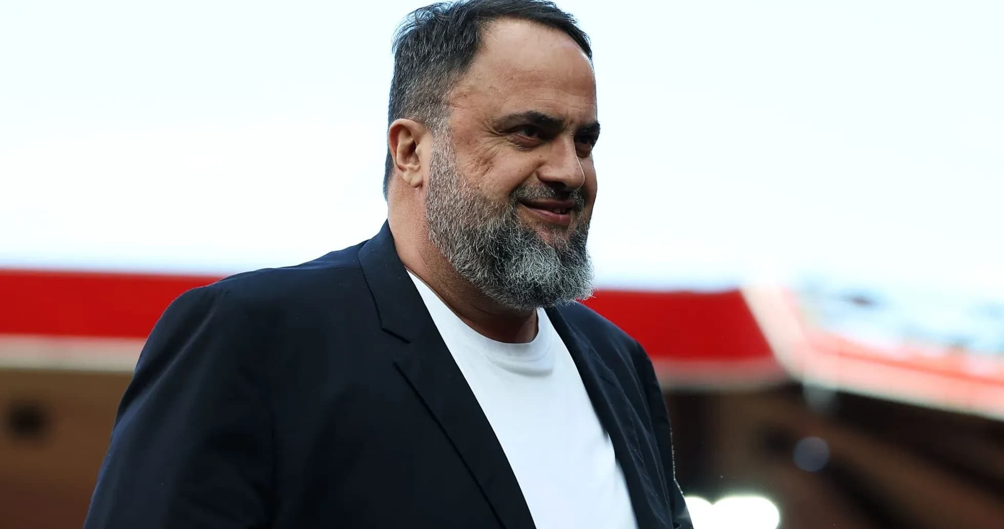 Man in a black blazer walking at stadium Man in a black blazer walking at stadium